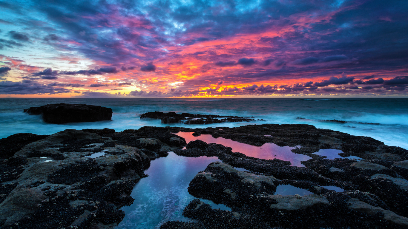 Download wallpaper 1366x768 sunset, rocky beach, clouds, nature, tablet,  laptop, 1366x768 hd background, 24340