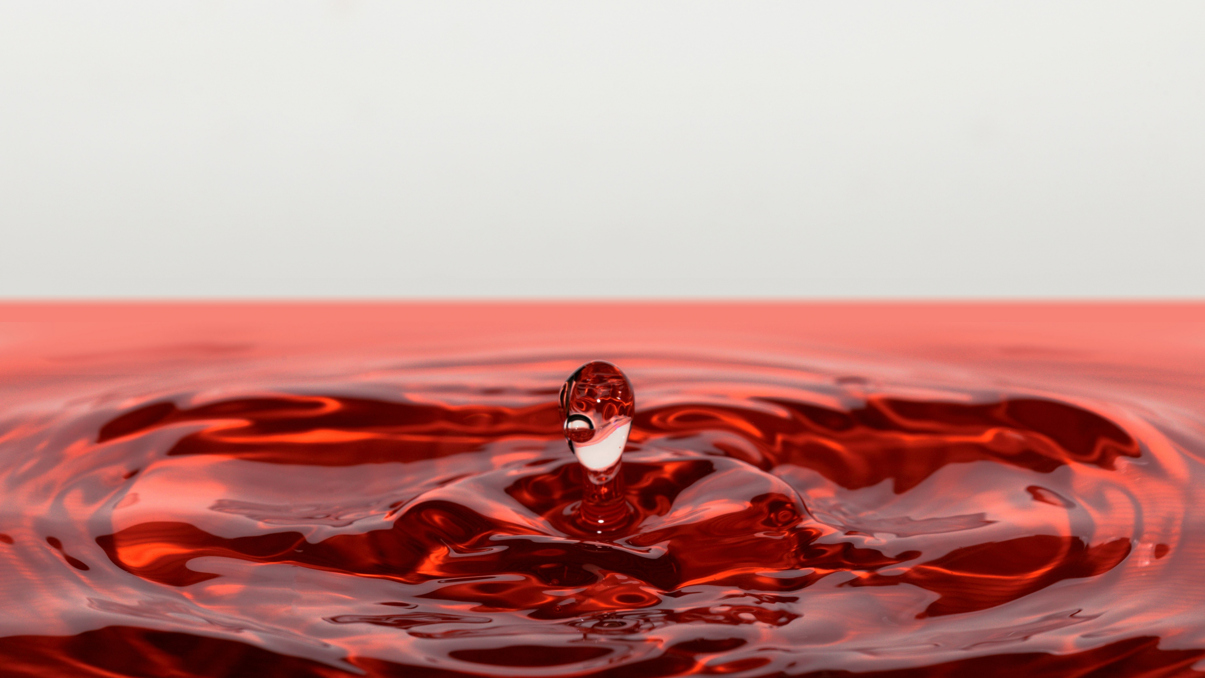 В воду идет красным. Капля. Красные капли воды. Вода красиво. Капли воды на Красном фоне.