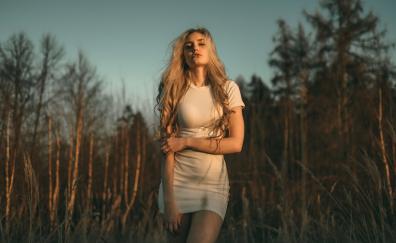 Blonde girl in white dress, sunrays on face, outdoor