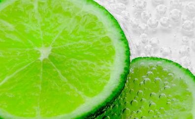 Green lemon slices, bubbles, close up